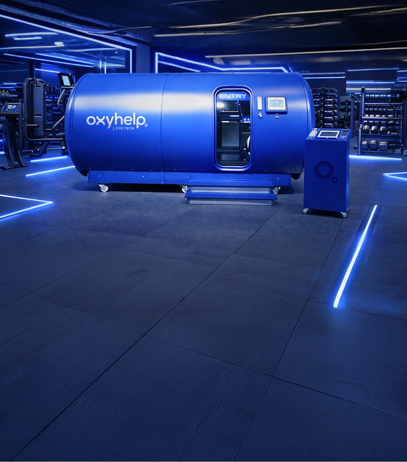 OxyLife Gym multiplace chamber on the floor of a gym, with the control unit beside the door