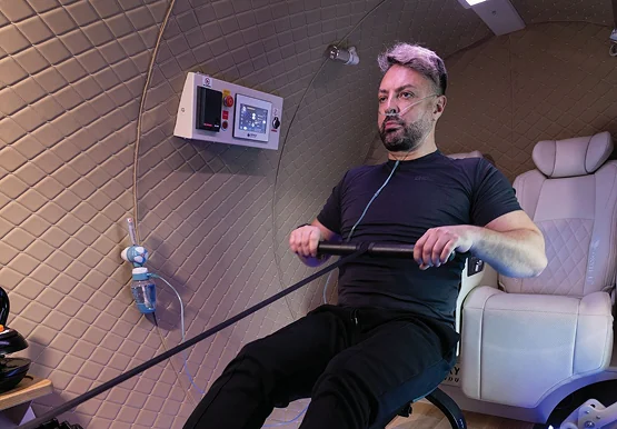 Athlete rowing inside an OxyHelp chamber